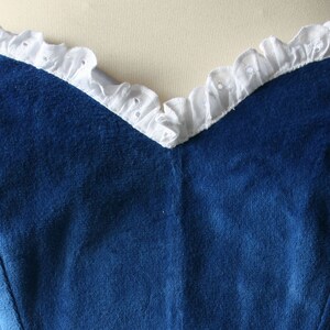 May include: A strapless blue velvet bodice with a white lace trim around the neckline.