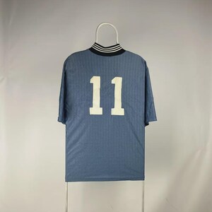 K&ouml;nnte beinhalten: Ein blaues Kurzarmtrikot mit der wei&szlig;en Nummer 11 auf dem R&uuml;cken. Der Kragen ist schwarz mit wei&szlig;en Streifen. Das Trikot h&auml;ngt an einem wei&szlig;en Kleiderb&uuml;gel.