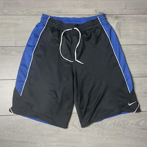 May include: Black athletic shorts with blue side panels and white trim. The shorts have a white drawstring and a small white Nike logo. The shorts are made of a lightweight, breathable material.