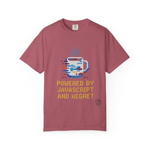 May include: A pink t-shirt with a pixelated image of a coffee mug and the text "Powered by Javascript and Regret".