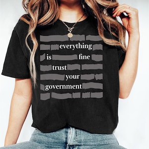 May include: A set of three ceramic mugs with a speckled, matte finish. The mugs are in shades of cream, light gray, and dark gray. Each mug has a simple, minimalist design and a rounded handle. The mugs are likely for coffee or tea.