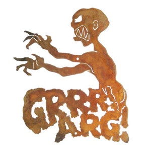 May include: A rusty metal cutout of a monster with the word "GRRR" written underneath. The monster has a menacing expression with sharp teeth and claws.