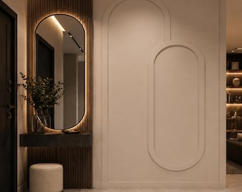 Op de afbeelding: Een aan de muur gemonteerde donkergrijze consoletafel met een achtergrond van verticale houten latten, een ovale spiegel met geïntegreerde achtergrondverlichting, een beige cilindrische poef en een beige muur met twee grote, overlappende ovale reliëfs.