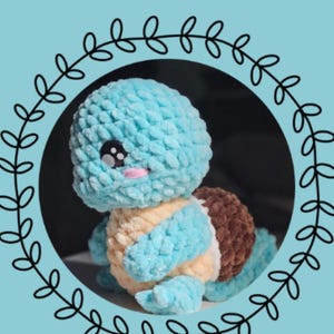 Op de afbeelding: Een gehaakte Squirtle-knuffel uit de "Chibi Series" met een lichtblauwe kop en ledematen, een beige buik en een bruin schild. De knuffel is omgeven door een zwarte bladerenrand. De tekst "Chibi Series: Squirtle" staat bovenaan.