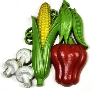 May include: A colorful, decorative kitchen accent featuring a corn cob, red bell pepper, green pea pods, and mushrooms. The corn is yellow, the pea pods and leaves are green, the pepper is red, and the mushrooms are white and gray.