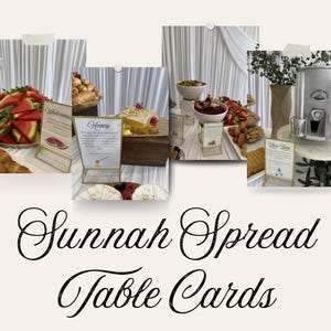 May include: A collection of rectangular table cards with gold frames, each featuring printed text and illustrations of food items like watermelon, honey, pomegranate, and Zam Zam water, displayed on a white draped table with various food platters.
