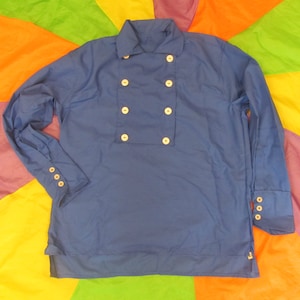 May include: A blue long-sleeved shirt with a double-breasted front and a mandarin collar. The shirt features eight cream-colored buttons and three buttons on each cuff. The garment is made of a smooth fabric.
