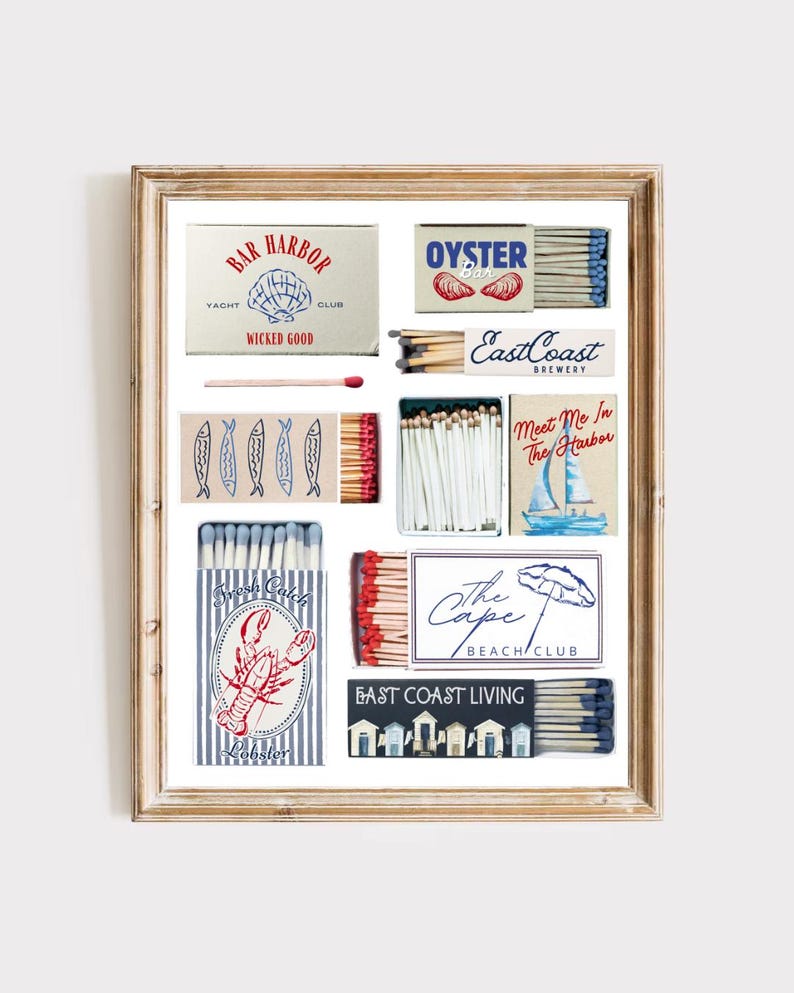 May include: A framed print featuring various matchbox designs with coastal themes. Boxes display text like "Bar Harbor Yacht Club," "Oyster Bar," and "East Coast Brewery." Other boxes show images of fish, a lobster, and a sailboat.