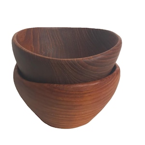 Könnte beinhalten: Zwei Holzschalen, die übereinander gestapelt sind. Die obere Schale ist dunkelbraun, die untere hellrotbraun. Beide haben ein glattes, geschwungenes Design und sind aus Holz gefertigt.