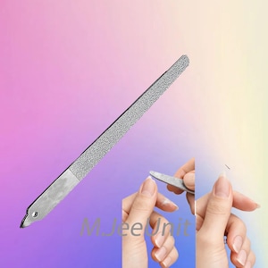 Op de afbeelding: Een zilveren nagelvijl met een getextureerd oppervlak en een glad metalen handvat. De afbeelding toont de vijl die op een nagel wordt gebruikt. De achtergrond is een verloop van roze, paars en geel.