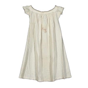 May include: Off-white, vintage-style nightgown. The gown features short sleeves, a scoop neckline with delicate trim, and a loose, flowing silhouette. The fabric appears to be lightweight and slightly textured, with subtle staining. A classic, comfortable sleepwear option.