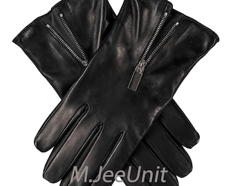 Puede incluir: Un par de guantes de cuero negro con cremalleras en el dorso de las manos. Los guantes son lisos y parecen estar hechos de cuero de alta calidad. Los tiradores de la cremallera son de color plateado.