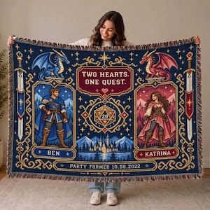 Puede incluir: Una manta tejida con fondo azul oscuro que presenta ilustraciones de fantasía de un personaje masculino y femenino, dos dragones, espadas y un dado de 20 caras. El texto dice: TWO HEARTS. ONE QUEST. BEN, KATRINA y PARTY FORMED 10.08.2022.