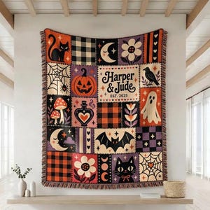 May include: A rectangular woven throw blanket featuring a patchwork design with Halloween-themed illustrations including a black cat, pumpkin, ghost, bat, spiderweb, mushrooms, and flowers. The text reads Harper & Jude EST. 2025 in black lettering.