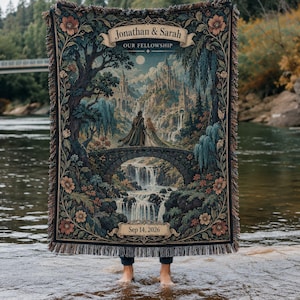May include: A woven throw blanket featuring a fantasy landscape with a couple standing on a stone bridge before a castle and waterfall. The text reads Jonathan & Sarah, OUR FELLOWSHIP, and Sep 14, 2026. The border is decorated with floral patterns.