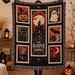 May include: A black woven throw blanket featuring a central vertical panel with a haunted house, full moon, and the text THE HARPER FAMILY, surrounded by six rectangular stamp-style illustrations of a pumpkin, ghost, cat, books, cauldron, and village.