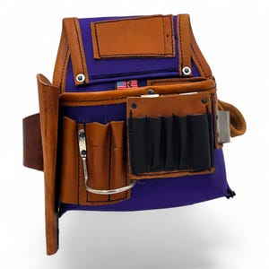May include: A purple and brown leather tool belt with multiple pockets and compartments. The belt features a brown leather holster for a hammer or other tool, and a metal clip. The belt has the American flag and the letters "R" and "E" on it.