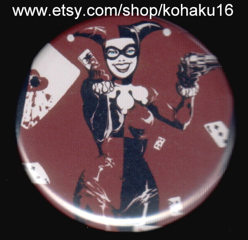 Puede incluir: Un bot&oacute;n rojo, blanco y negro con una imagen estilizada de Harley Quinn, un personaje de c&oacute;mic, sosteniendo un arma y una carta de juego. El fondo es un patr&oacute;n rojo y blanco de cartas de juego.