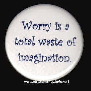 May include: White round button with blue text that reads "Worry is a total waste of imagination."
