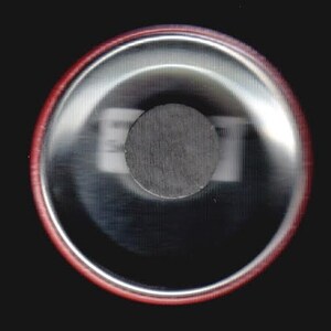 Puede incluir: Un bot&oacute;n redondo de color plateado con un borde rojo. El bot&oacute;n tiene un im&aacute;n circular negro en el centro.