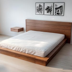 Puede incluir: Una cama de madera moderna con cabecero a juego y dos mesitas de noche flotantes. La cama tiene un perfil bajo y un colchón blanco. Tres obras de arte en blanco y negro enmarcadas cuelgan sobre la cama.