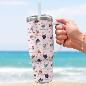 Puede incluir: Un vaso grande y aislado con un asa y una pajita blancas. El vaso presenta un patr&oacute;n repetido de personajes de dibujos animados y texto sobre un fondo rosa claro. El texto incluye nombres como "Mr. Big" y "Judy Hopps".