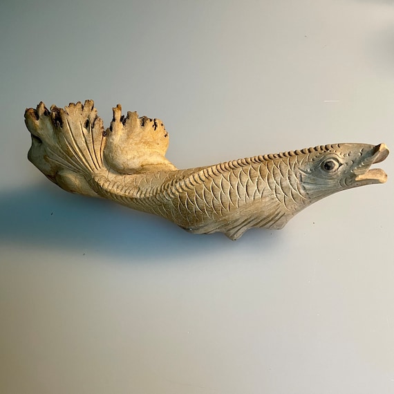天然木で彫られた魚の彫刻 — 自然の渦巻きと節のある、まさに
