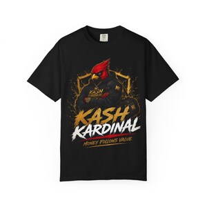 Könnte beinhalten: Ein schwarzes Kurzarm-T-Shirt mit einer Grafik eines roten Kardinalvogels, der einen schwarzen Kapuzenpullover und Goldschmuck trägt. Der Text KASH KARDINAL und MONEY FOLLOWS VALUE ist in Gold und Weiß unter dem Vogel aufgedruckt.