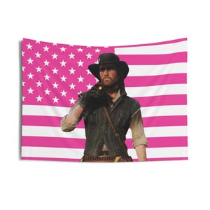 May include: A tapestry featuring a man in a cowboy hat and vest, set against a pink and white American flag. The man is holding a lit object. The flag has white stars on a pink background and pink and white stripes.