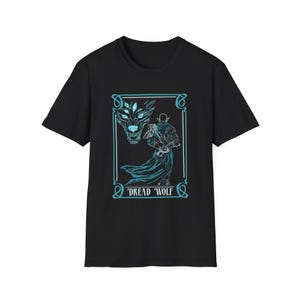 May include: Black t-shirt with a blue and white graphic of a wolf and a figure with a sword. The graphic is in a frame with the text "Dread Wolf".