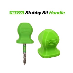 Pode incluir: Duas pegas de pontas curtas verdes, uma com uma ponta presa. As pegas estão rotuladas "Kliko" e o texto "FESTOOL Stubby Bit Handle" está acima delas. As pegas são de cor verde brilhante.