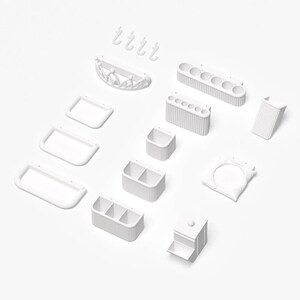 May include: A collection of white, minimalist bathroom organizers and accessories. Includes rectangular trays, toothbrush holders, a soap dish, hooks, and storage containers. The items are arranged on a white surface.