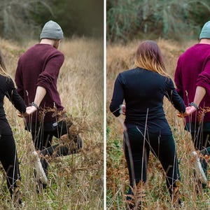 May include: Two individuals walking through a field of tall, dry grass. One wears a black long-sleeved top and black pants, while the other wears a maroon sweater, black pants, and a beanie. The image shows a before and after color edit.