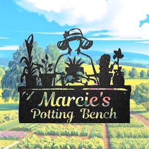 Puede incluir: Letrero de metal negro con la silueta de una persona con sombrero en un banco de macetas con plantas en macetas. El letrero dice "Marcie's Potting Bench" en una fuente decorativa, sobre un fondo paisajístico.