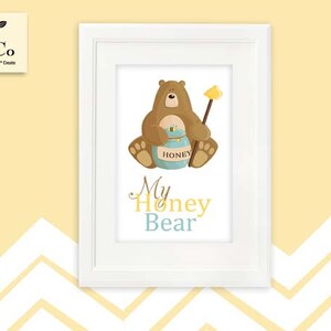 May include: A white framed print with a brown bear holding a honey pot. The text "My Honey Bear" is written in blue and yellow letters.