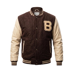Könnte beinhalten: Braune Collegejacke mit beigefarbenen Ärmeln und einem beigefarbenen "B"-Aufnäher. Die Jacke hat eine Knopfleiste, einen gerippten Kragen, Bündchen und einen Saum. Die Jacke ist aus einem strukturierten Material.