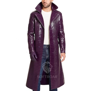 May include: A long, purple trench coat with a crocodile-effect texture. The coat has a wide collar, double-breasted design, and matching gloves. The coat is worn over a white top and blue jeans. The coat is made of faux leather.