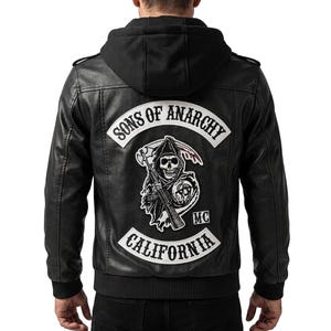 May include: Black leather jacket with a hood. The back features a large patch with the words "SONS OF ANARCHY" and "CALIFORNIA" surrounding a grim reaper graphic. The jacket has a ribbed hem and cuffs.
