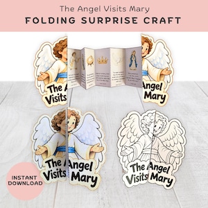 May include: A paper folding surprise craft titled The Angel Visits Mary, featuring colourful and black-and-white illustrations of an angel with wings. The centre accordion-style panel displays religious text and small drawings of a crown, dove, and Mary.