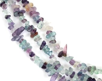 May include: Strands of colorful, irregular-shaped fluorite gemstone beads. The beads display a variety of colors, including purple, green, and clear, with a polished, slightly translucent appearance. The beads are strung together, creating a textured and visually appealing design.