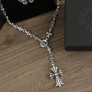 以下が含まれることがあります： 黒いハンドルと「But First, Coffee」のテキストが黒い太字で書かれた白いセラミックマグ。マグは木製の表面に置かれています。マグの高さは10cmです。