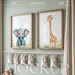 Puede incluir: Dos impresiones en acuarela enmarcadas con un elefante bebé y una jirafa. El elefante es azul con detalles rosas, y la jirafa es marrón y amarilla. Los marcos de madera cuelgan de una pared verde claro. Debajo, una barra de madera sostiene varias bolsas de lona pequeñas.