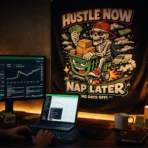Puede incluir: Un tapiz de pared negro con las palabras "Hustle Now, Nap Later" y un esqueleto de dibujos animados empujando un carrito de compras lleno de cajas. El esqueleto lleva gafas de sol y una gorra roja. Se ven un monitor de ordenador y un portátil.