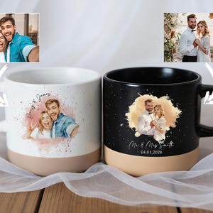 Könnte beinhalten: Zwei Keramikbecher mit personalisierten Fotodrucken. Einer ist weiß mit rosa und beigem Boden, mit einem Foto eines Paares und den Namen "Daisy & James". Der andere ist schwarz mit beigem Boden, einem Paar-Foto und dem Text "Mr & Mrs Smith 04.01.2026."
