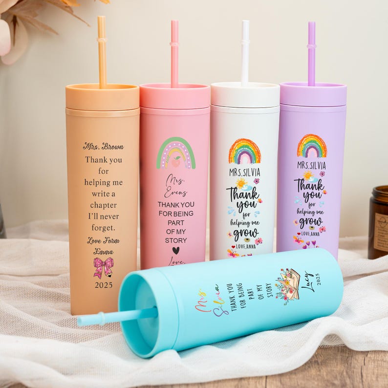 May include: A collection of colorful insulated tumblers with straws. Each tumbler features a different pastel color and personalized text, including phrases like "Thank you for helping me grow" and names like "Mrs. Brown" and "Lucy".