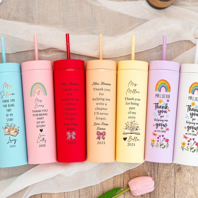 May include: A collection of insulated tumblers in various colors, each with a straw and personalized text. The tumblers feature phrases like "Thank you for being part of my story" and are decorated with rainbows, flowers, and names.