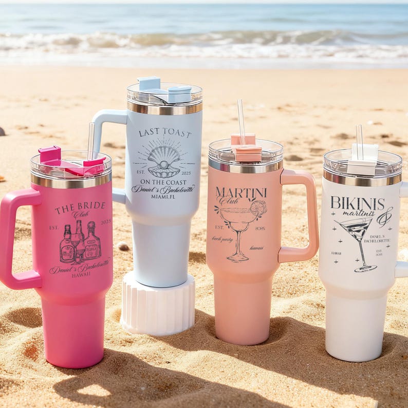 Pu&ograve; includere: Quattro bicchieri isolati con manici e cannucce su una spiaggia sabbiosa. I bicchieri sono rosa, azzurro, pesca e bianchi. Ogni bicchiere ha un design e un testo diverso, tra cui "The Bride Club", "Last Toast", "Martini Club" e "Bikinis + Martinis".