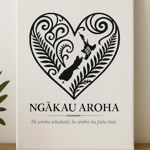 May include: Black and white print of a heart-shaped design featuring a stylized fern pattern and an outline of New Zealand. The text "NGĀKAU AROHA" is below the heart, and the text "He aroha whakatō, he aroha ka puta mai." is below that.