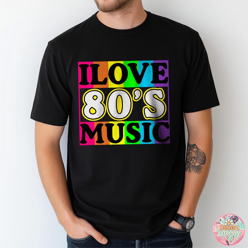 May include: Black t-shirt with the text "I LOVE 80'S MUSIC" in a colorful retro design. The text is in a rectangular block with a rainbow gradient background. The shirt is short-sleeved.