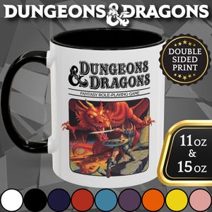 May include: White ceramic mug with a black handle and interior. The mug features the "Dungeons & Dragons" logo and a fantasy scene with a dragon and warrior. The mug is available in 11 oz and 15 oz sizes.